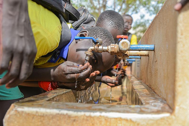 Nyumanzin koulun oppilaat juomassa vettä vesihanoilla