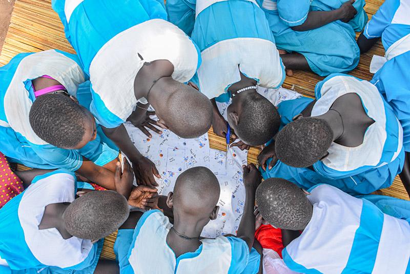 Koululaiset valmistavat pestäviä kuukautissuojia Amelon peruskoulussa Adjumanissa Ugandassa.